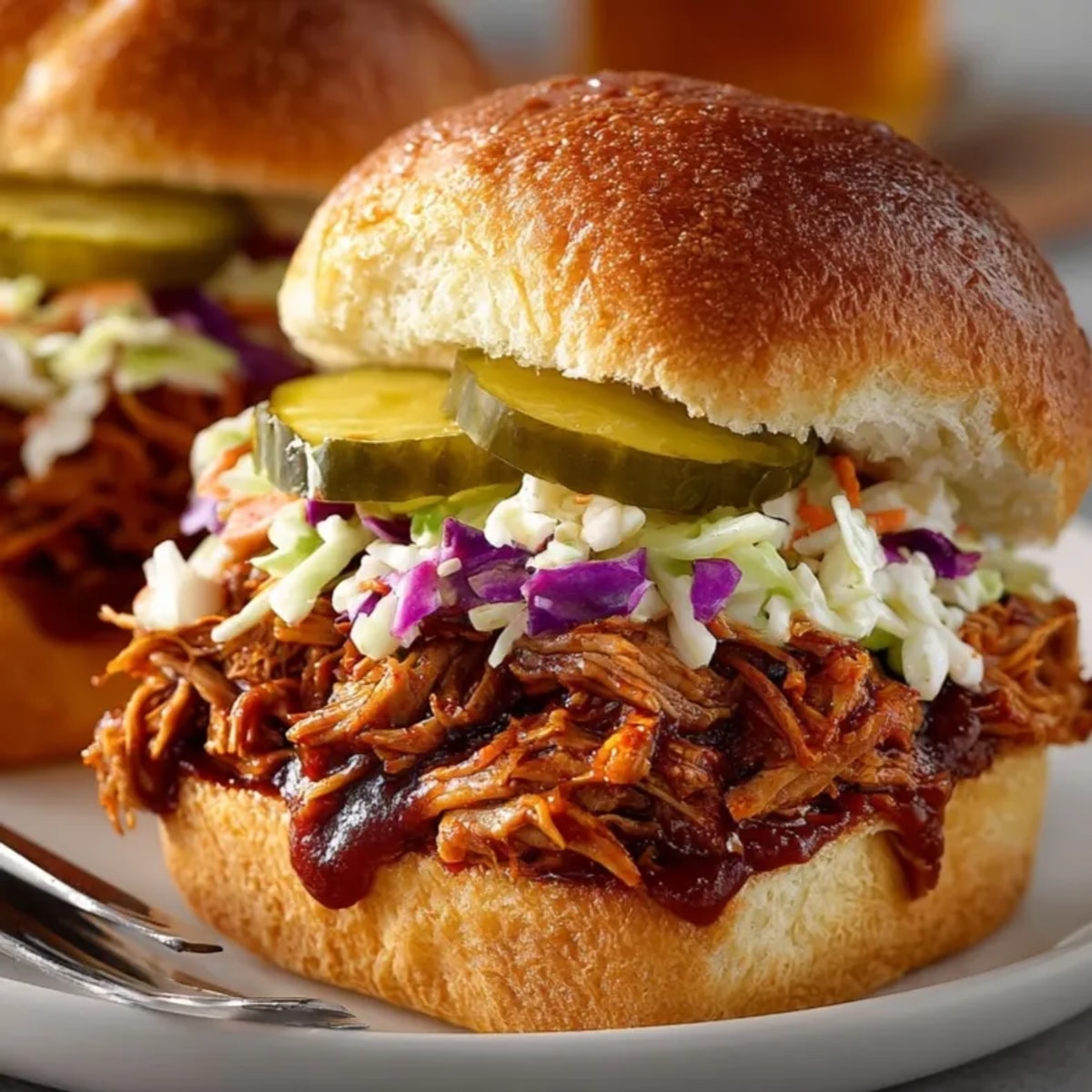 BBQ chicken sliders, spicy and juicy, piled high on toasted mini buns ready to serve.