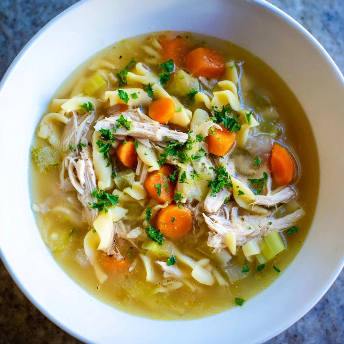 A close-up shot of rich and flavorful homemade chicken noodle soup, ready to serve and enjoy.