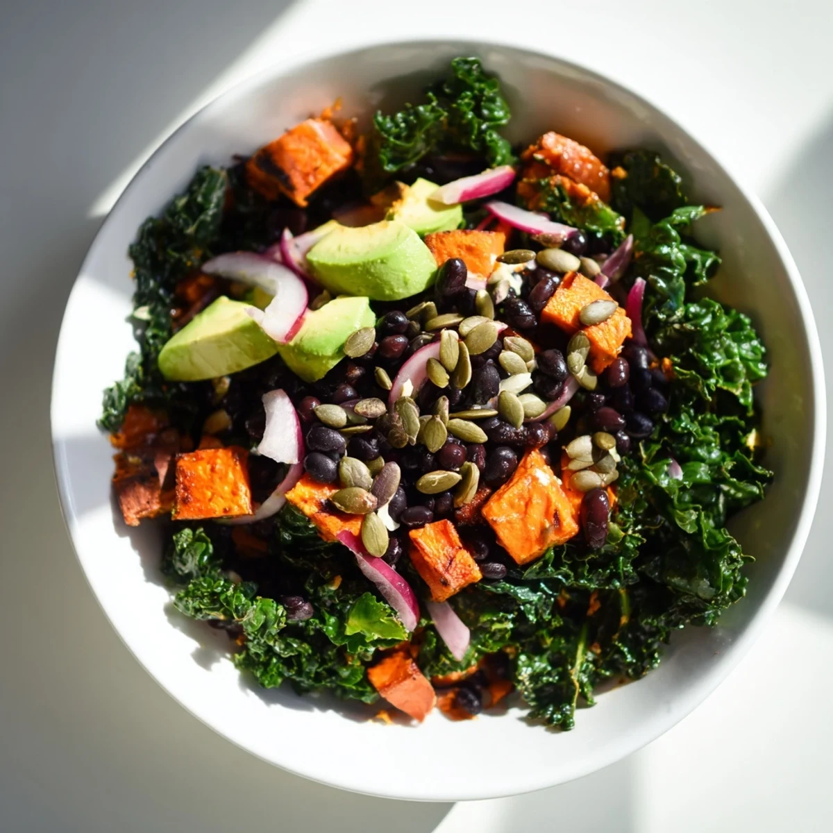 Massaged kale salad with sweet potato and beans, tossed in a bright lime dressing.