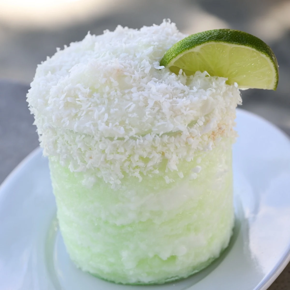 Creamy coconut and lime White Christmas Margarita Slush bursting from a chilled glass, garnished beautifully.