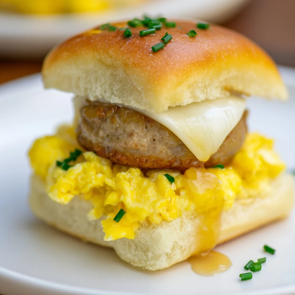 Golden-brown Mini Breakfast Sliders filled with fluffy eggs, melted cheese, and a sweet maple drizzle.