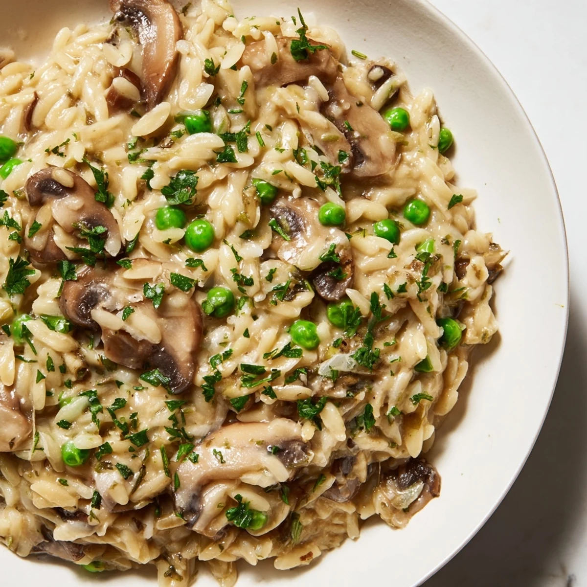 A close-up shot of the flavorful orzo mushroom risotto-style, showcasing the creamy texture and rich broth.