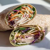 Sliced turkey combined with zesty cranberry apple slaw nestled in a whole wheat wrap, ready to eat.