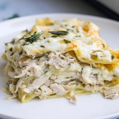 A steaming Rosemary Chicken Lasagna, layered with creamy béchamel, baked to golden perfection.