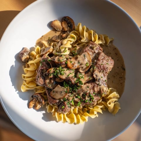 Creamy Mushroom Beef Stroganoff with noodles, a rich, savory sauce ready to enjoy on your plate.