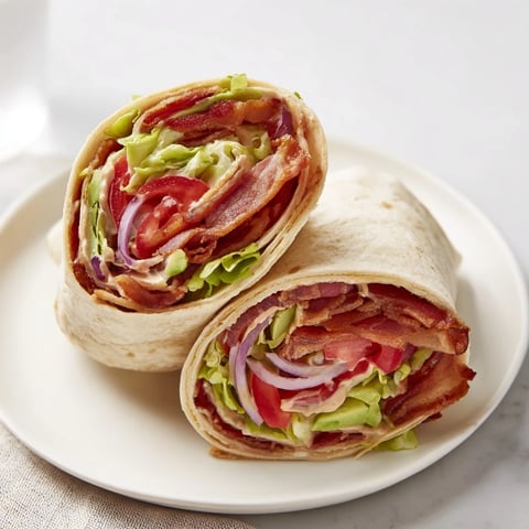 Zesty BLT Wraps with Chipotle Mayo: a close-up shows bacon, tomatoes, and creamy chipotle sauce in a wrap.