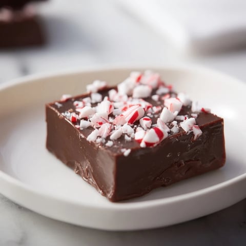 Melting chocolate and sprinkles topping the easy 3-Ingredient Christmas Fudge Squares in a pan.