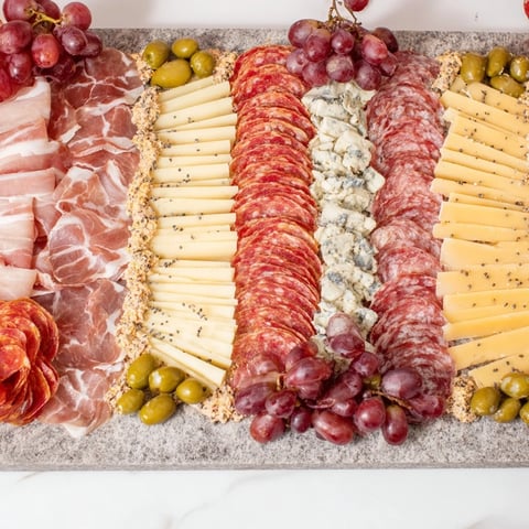 The Industrial Slate appetizer, a visually striking charcuterie board with sliced meats and cheeses.
