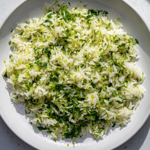 Fluffy Cilantro Lime Rice glistening with lime, a bright green, flavorful accompaniment to any meal.