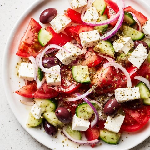 A colorful Mediterranean salad with tomatoes, cucumbers, and creamy feta, ready to enjoy.