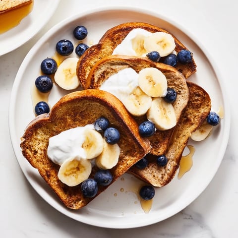 Golden-brown Protein French Toast, topped with fresh berries, offering a delightful and healthy breakfast.