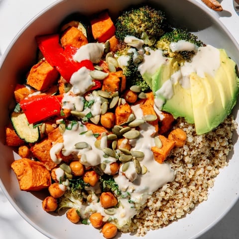 Fluffy quinoa Buddha bowl topped with roasted veggies, creamy tahini dressing, a truly colorful and healthy meal.