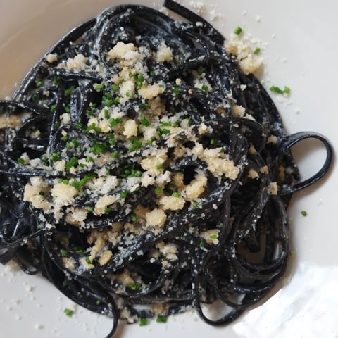 Silky, pitch-black Squid Ink Pasta twirls on a fork, ready for a taste of Italian luxury.