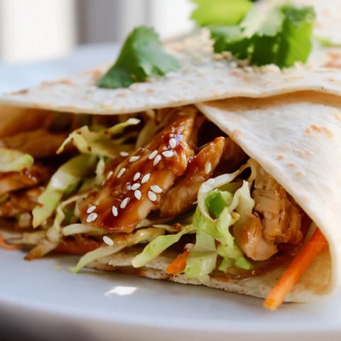 Golden glazed teriyaki chicken strips layered with crisp shredded cabbage and carrots inside a soft flour tortilla.  