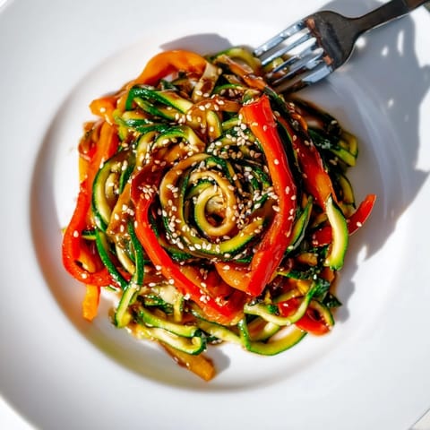 Quick and healthy zucchini noodle stir-fry, drizzled with savory sesame oil.  