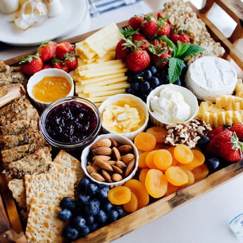 Delicious jam-infused brunch board arranged beautifully with fresh berries and creamy cheeses.  