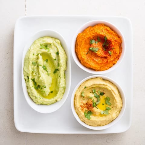 Platter of Dip Trio showcasing creamy dips, each flavored differently and perfect for sharing with friends.