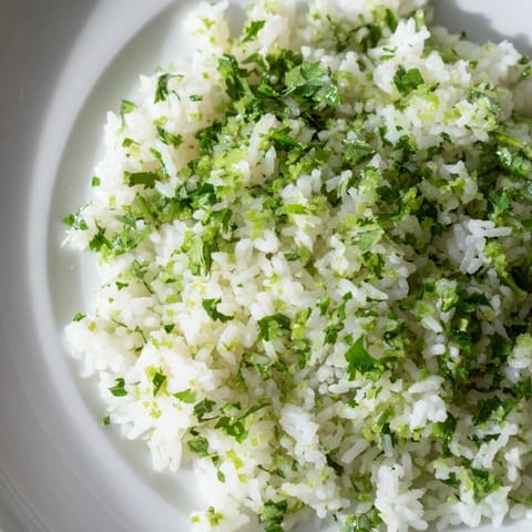 Close up shows freshly prepared Cilantro Lime Rice, vibrant with cilantro and lime zest, ready to be served.