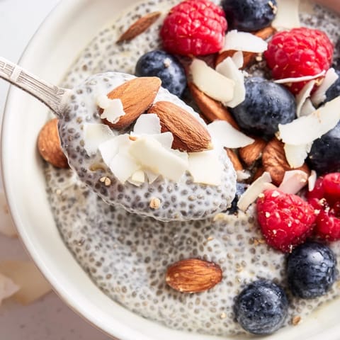 A close-up of chilled Poppy Seed Chia Pudding showing the gel-like texture with poppy seeds and a drizzle of maple syrup for sweetness.