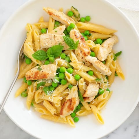 Penne pasta tossed with golden chicken, vibrant peas, and mint, topped with grated Parmesan.  