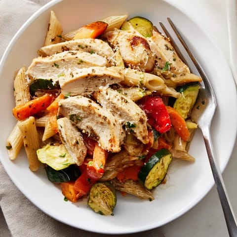 A plated serving of Garlic Herb Chicken & Veg Pasta tossed with fresh parsley, Parmesan, and a light, aromatic sauce.  