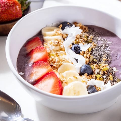 Delicious acai berry smoothie bowl artfully arranged with seeds and berries.