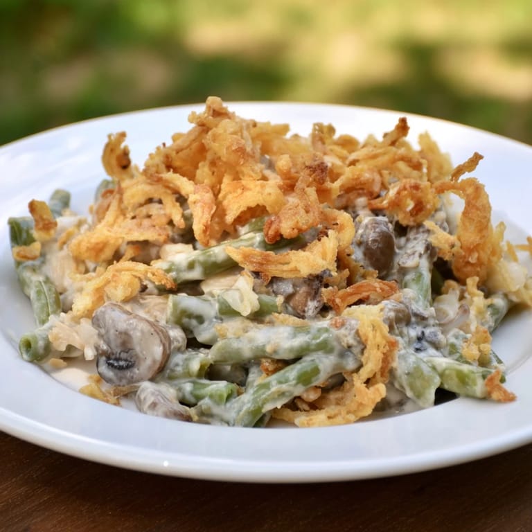 A warm baking dish filled with homemade Old-School Green Bean Casserole, a classic comfort food.