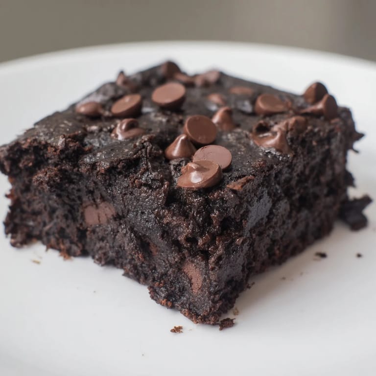 Close-up of baked Black Bean Brownies, dark and dense, perfect with a scoop of vanilla ice cream.