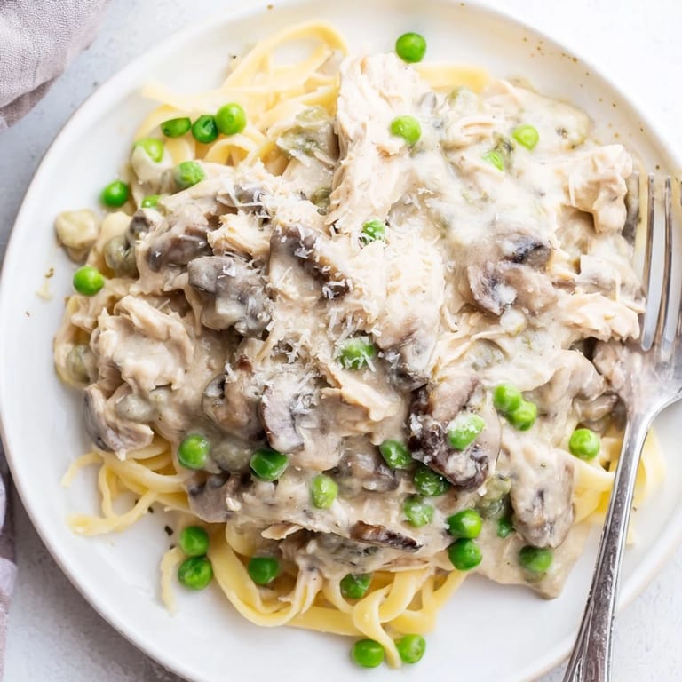 A close-up view of the slow-cooker Creamy Chicken Alfredo, showcasing the creamy sauce and chicken.