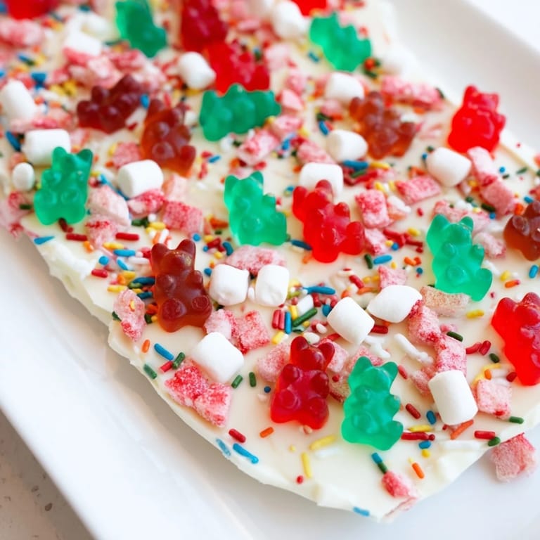 Close-up view of a delicious dessert: White chocolate topped with gummy bears and candy canes for a holiday snack.